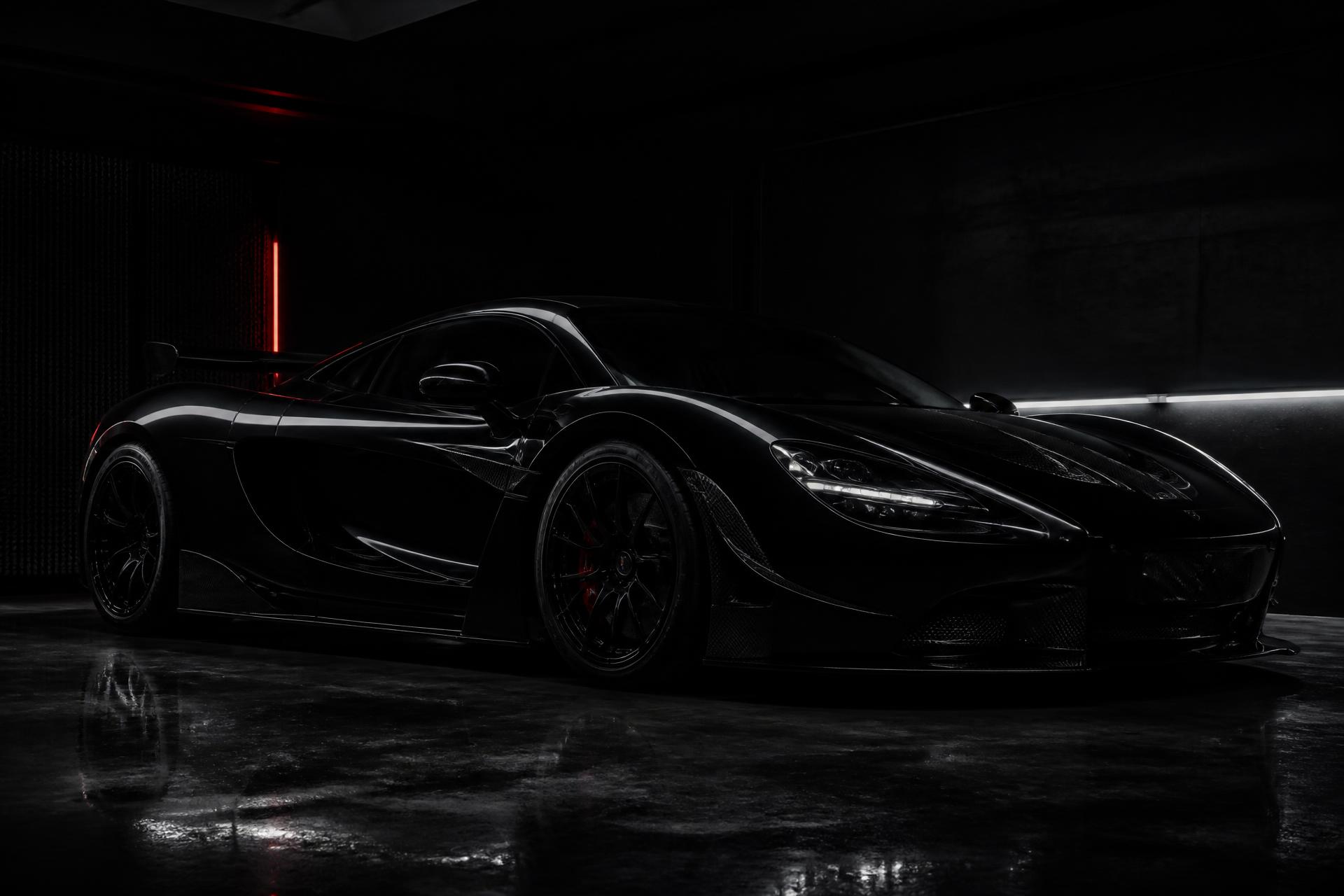 Black exotic supercar in a dark premium service garage